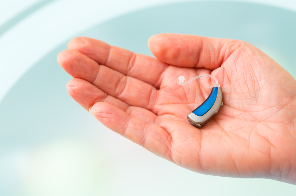Caring for Hearing Aids and Earmolds a hearing aid in a hand