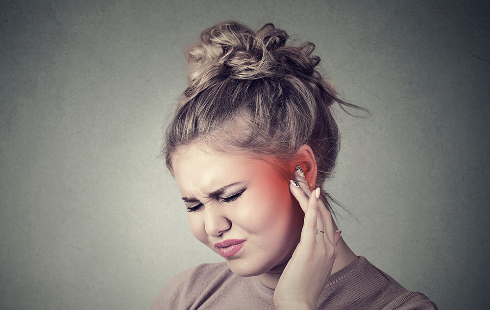 What are the most effective treatments for tinnitus? a woman experiencing slight ear discomfort